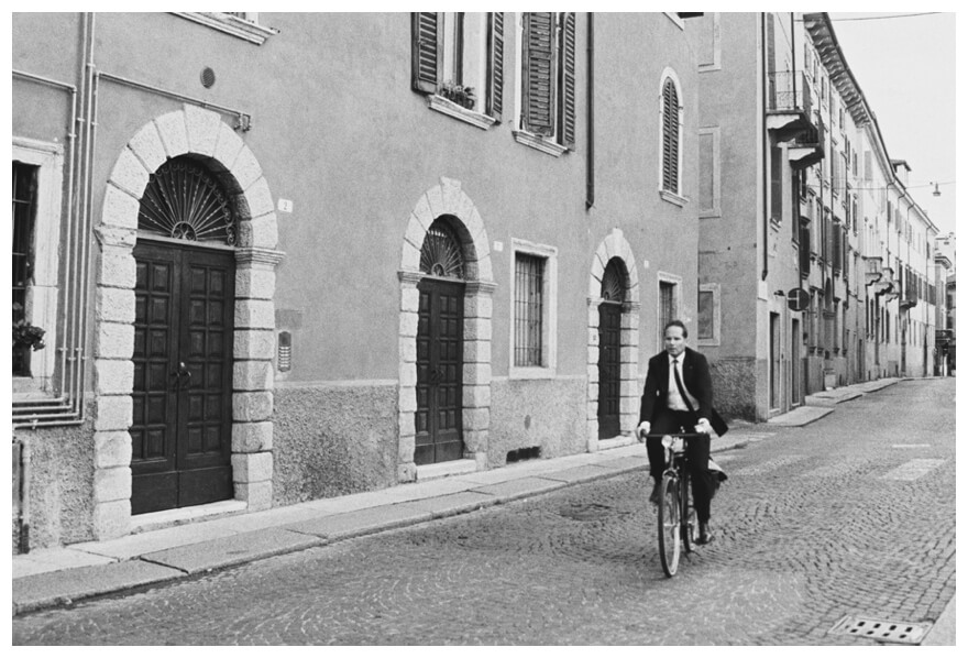 Man cycling down the street in Verona by Cyntia Apps Photography