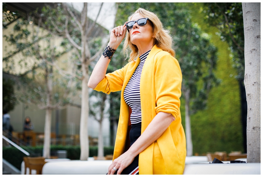 Woman with Yellow Suit Holding Sunglasses