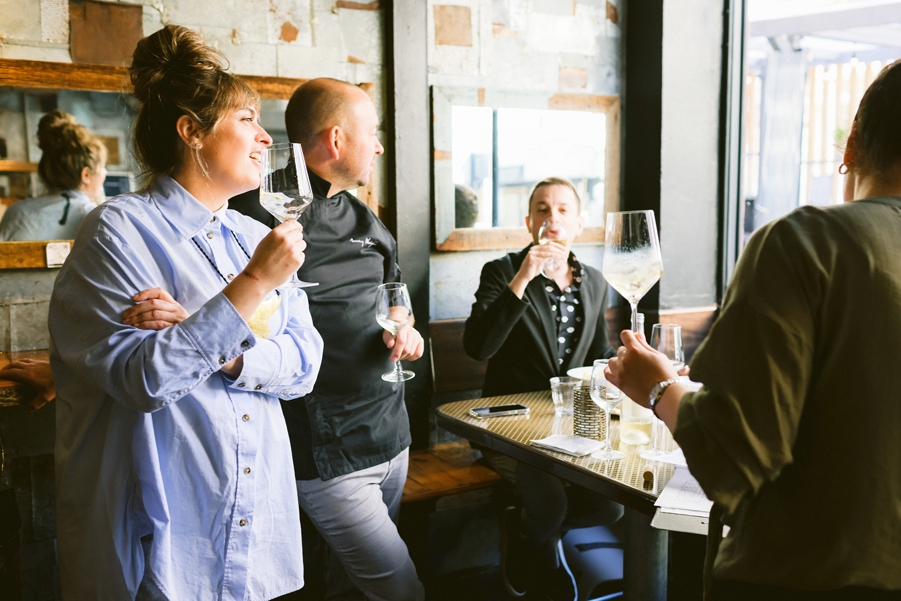 Group of people enjoying wine together inside a California restaurant during a professional food and wine photography session.