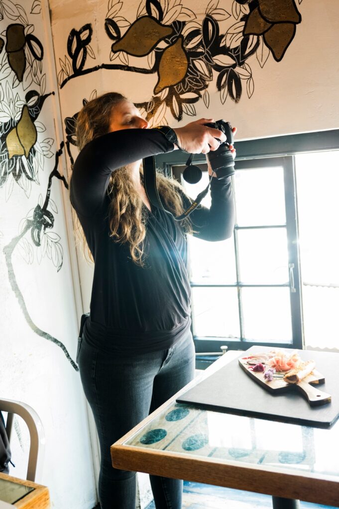 Culinary photography students capturing top-down food shots on wooden tables,