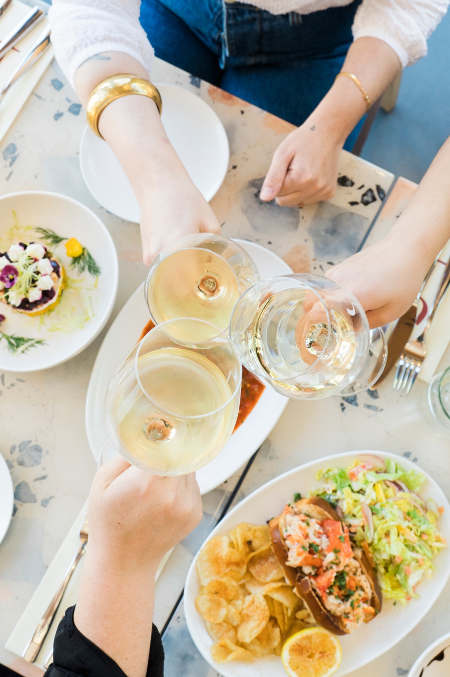 Women toasting with wine glasses at Vera Restaurant, captured by Cyntia Apps, San Francisco Bay Area food photographer
